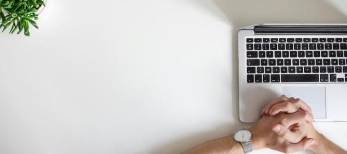 Image of hands over a laptop with a watch on left wrist. Photo by NordWood Themes on Unsplash  