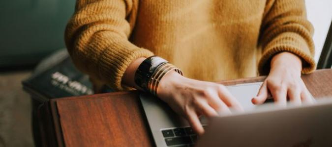 Image of a person typing on a laptop. Photo by Christin Hume on Unsplash